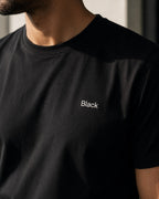 Close-up of the Black wordmark on the chest, worn