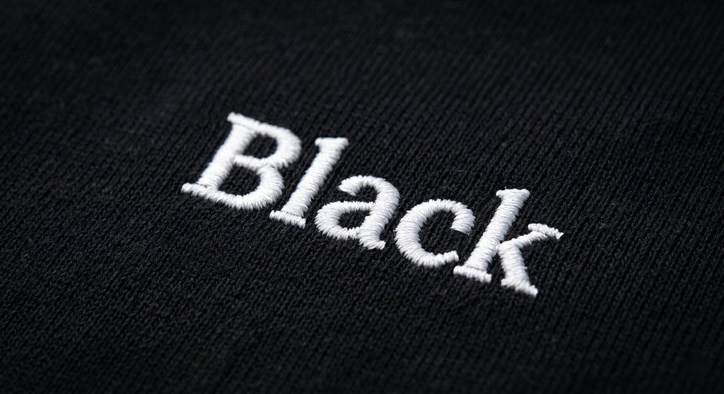 Close-up of white embroidered Black wordmark on the chest